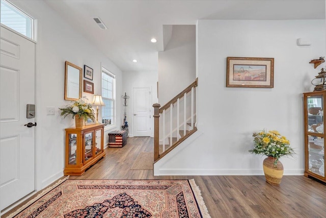 entrance foyer with visible vents, wood finished floors, stairway, baseboards, and recessed lighting