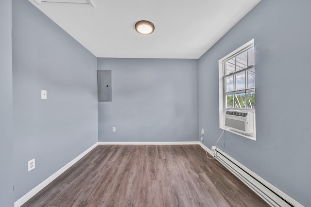 empty room featuring a baseboard heating unit, electric panel, wood finished floors, and baseboards
