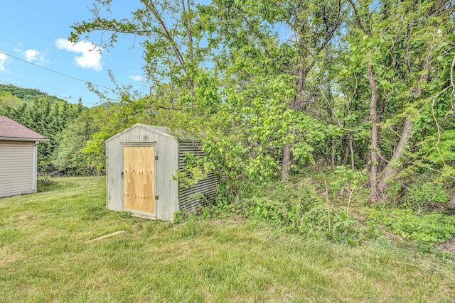 view of shed featuring a view of trees