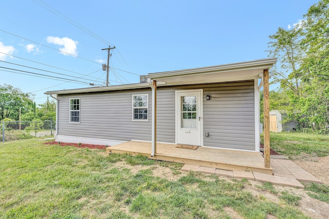 rear view of house with a shed, an outdoor structure, and a deck