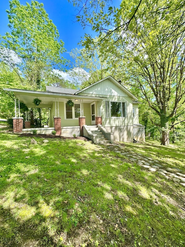 view of front of property featuring covered porch and a front lawn