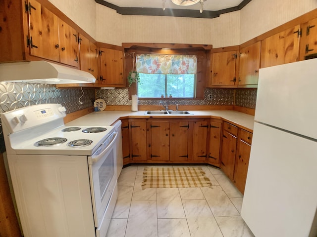 kitchen featuring under cabinet range hood, brown cabinetry, white appliances, a sink, and light countertops