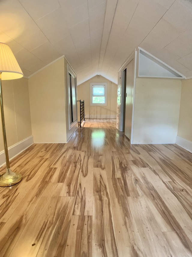 additional living space featuring vaulted ceiling, baseboards, and wood finished floors