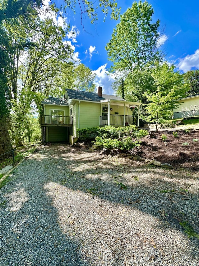 view of side of home with driveway and a chimney