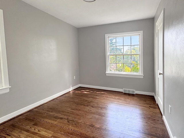 unfurnished room featuring dark wood-style flooring and baseboards