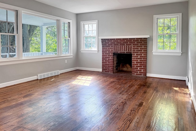 unfurnished living room with dark wood-style floors, a fireplace, and baseboards