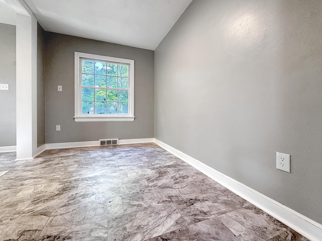 spare room with baseboards