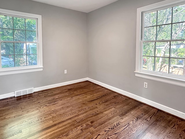 empty room with plenty of natural light and dark wood finished floors