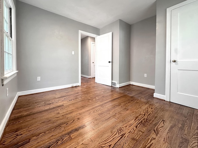 spare room featuring dark wood finished floors and baseboards