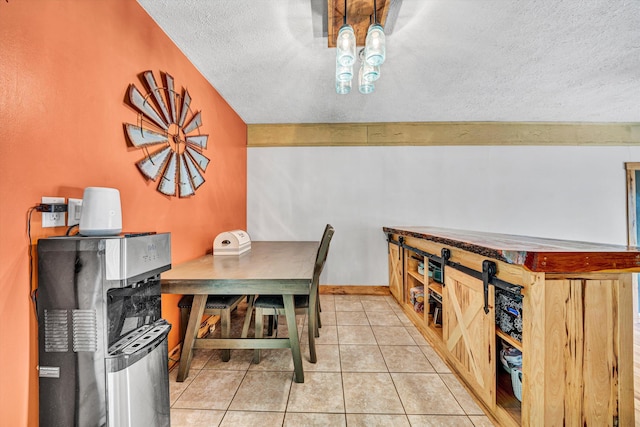 dining space with a textured ceiling and light tile patterned floors