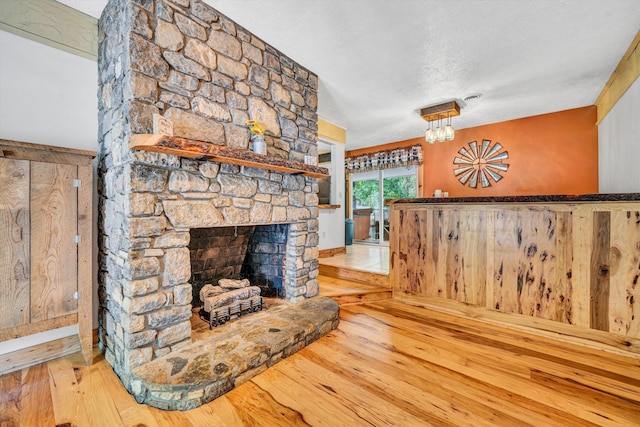 unfurnished living room featuring a fireplace, wood-type flooring, and a textured ceiling