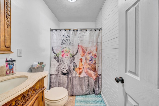 bathroom with vanity, toilet, a shower with shower curtain, a textured ceiling, and tile patterned floors
