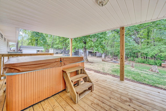 wooden terrace featuring a lawn, an outdoor structure, and a hot tub
