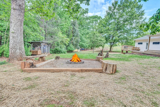 view of yard with a wooden deck and an outdoor fire pit