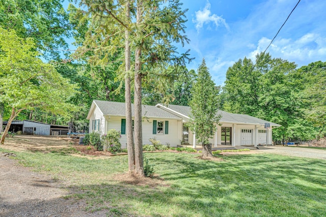 single story home with dirt driveway, a front yard, and a garage