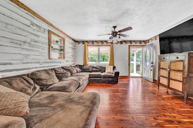 living room featuring a textured ceiling, ceiling fan, and wood finished floors