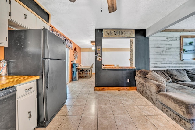 kitchen with ceiling fan, a textured ceiling, white cabinetry, light tile patterned floors, and black appliances