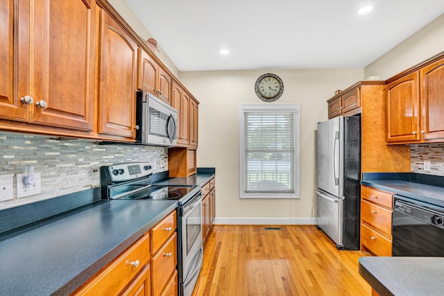80 Farmers Cir, Moneta, VA 24121 - kitchen featuring stainless steel appliances, light wood-style floors, baseboards, dark countertops, and brown cabinets