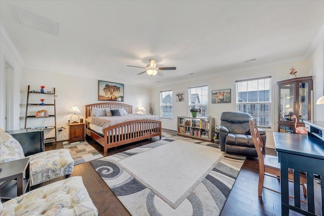 bedroom with wood finished floors, a ceiling fan, crown molding, visible vents, and baseboards