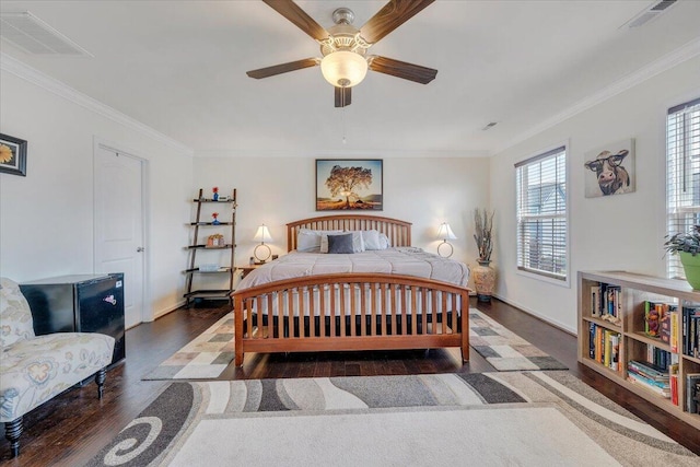 bedroom with crown molding, visible vents, and wood finished floors