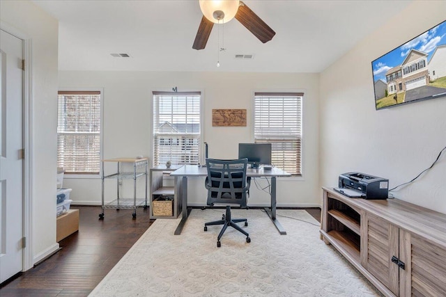 home office featuring baseboards, a ceiling fan, visible vents, and wood finished floors