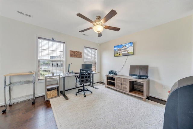 office space featuring baseboards, ceiling fan, visible vents, and wood finished floors