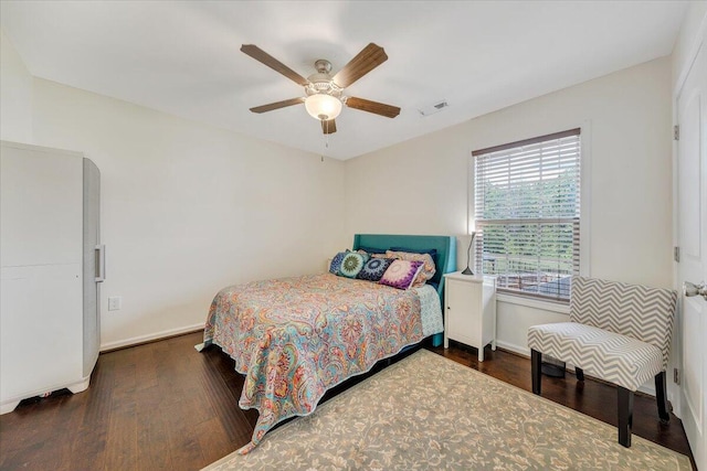bedroom with baseboards, visible vents, and wood finished floors