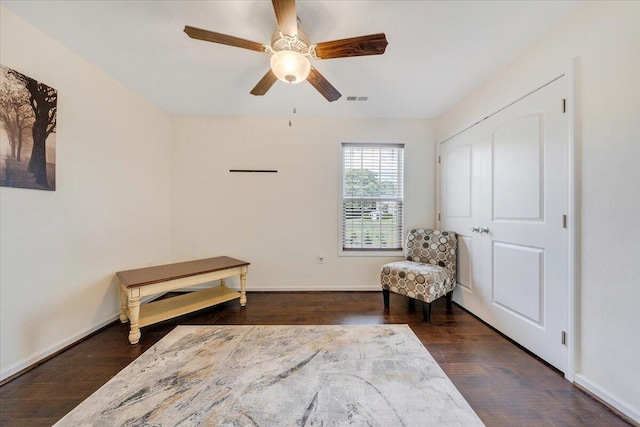 sitting room with visible vents, wood finished floors, baseboards, and ceiling fan