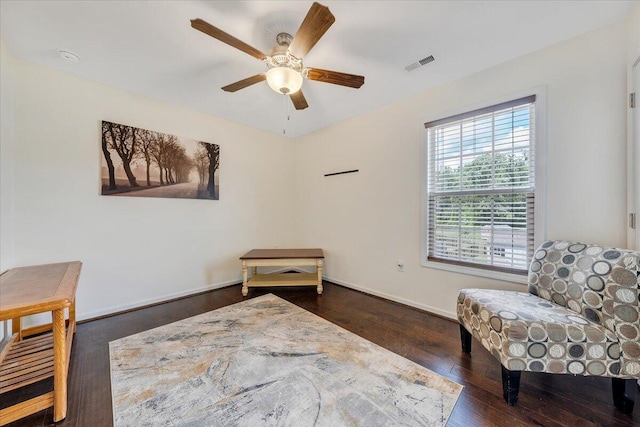 living area with ceiling fan, baseboards, visible vents, and wood finished floors