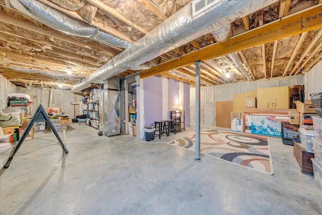 unfinished basement with heating unit and visible vents