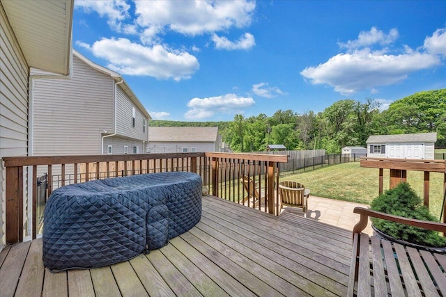 wooden deck featuring a yard, an outdoor structure, a shed, and fence