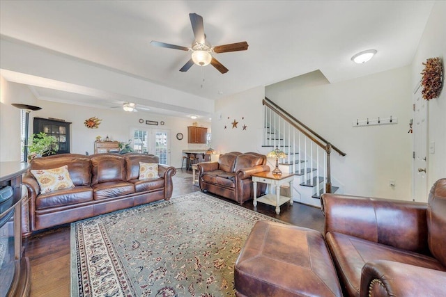 living room with stairway, wood finished floors, and ceiling fan