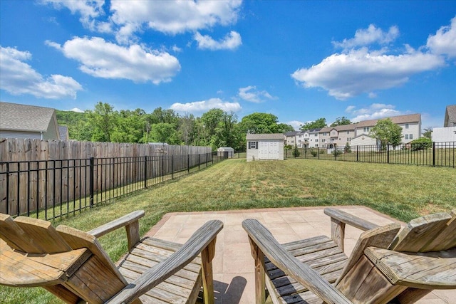 view of patio with a storage unit, a fenced backyard, and an outbuilding