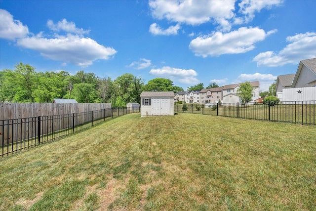 view of yard with a fenced backyard, a storage shed, an outdoor structure, and a residential view