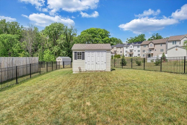 view of yard with a fenced backyard, a storage shed, an outbuilding, and a residential view