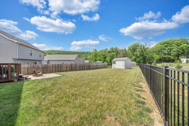 view of yard with an outbuilding, a patio, a fenced backyard, and a storage unit