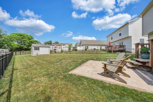 view of yard featuring a patio, a residential view, a storage unit, an outdoor structure, and a fenced backyard