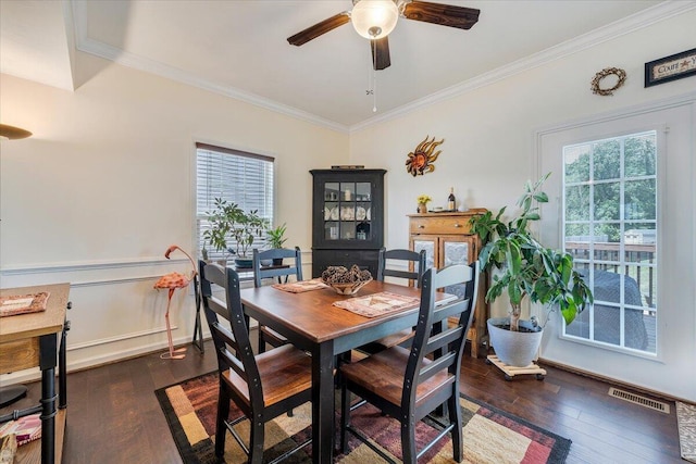 dining space with ornamental molding, visible vents, ceiling fan, and dark wood-type flooring