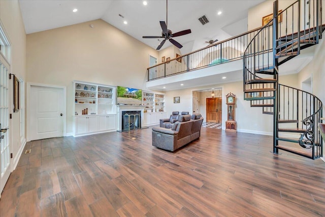 living room with visible vents, stairs, a fireplace, ceiling fan, and high vaulted ceiling