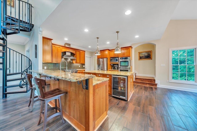 kitchen featuring wine cooler, baseboards, dark wood-style floors, wall chimney exhaust hood, and appliances with stainless steel finishes
