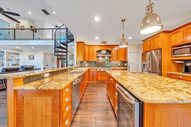 kitchen with wine cooler, ceiling fan, wall chimney range hood, a sink, and appliances with stainless steel finishes