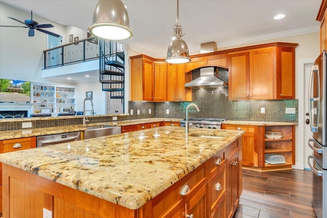 kitchen with a sink, wall chimney exhaust hood, appliances with stainless steel finishes, and light stone countertops