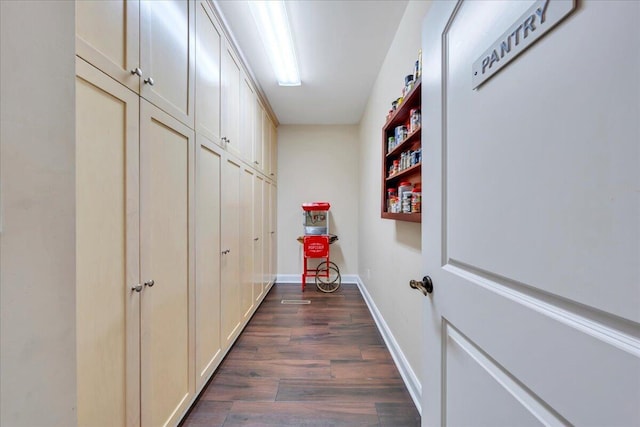 hall featuring baseboards and dark wood finished floors