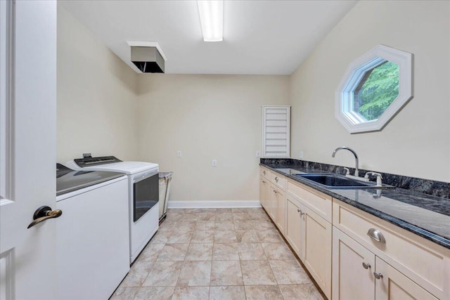 clothes washing area with a sink, baseboards, cabinet space, and washer and dryer