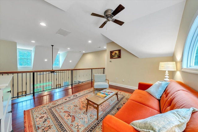 living area featuring a ceiling fan, lofted ceiling, wood finished floors, and a wealth of natural light