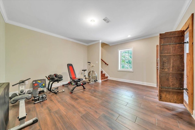 workout area with crown molding, baseboards, wood finished floors, and visible vents