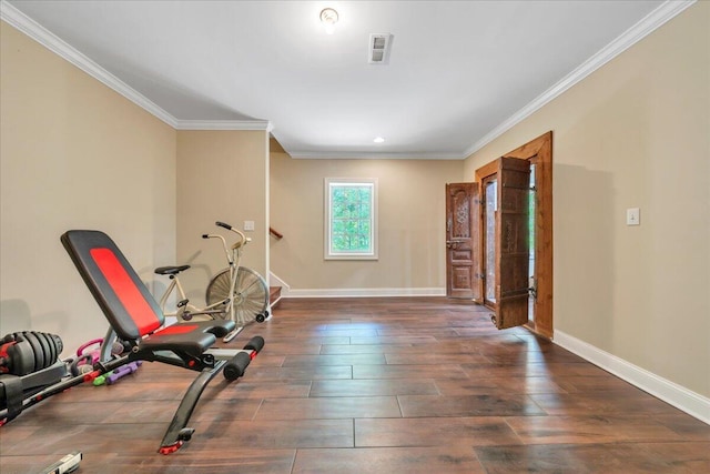 workout room featuring wood-type flooring, baseboards, and ornamental molding