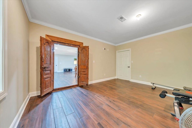 spare room with dark wood-style floors, baseboards, visible vents, and ornamental molding