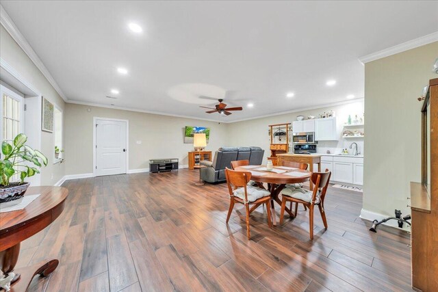 dining room with crown molding, dark wood-style flooring, a ceiling fan, and recessed lighting