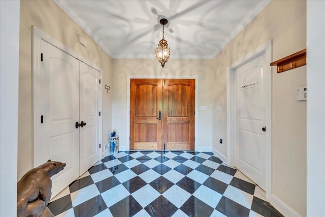 foyer entrance with crown molding, dark floors, a chandelier, and baseboards